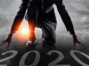 this is a picture of a guy on one knee with his hands on the ground with 2020 in front of him