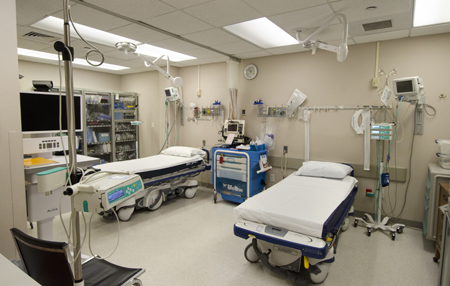 This is a picture of a patient laying in a er hospital bed. with three nurses and a doctor standing around the patient